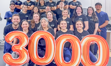 STHS McAllen Outpaitent Rehab Center Staff poses with 3000-shaped Mylar balloons
