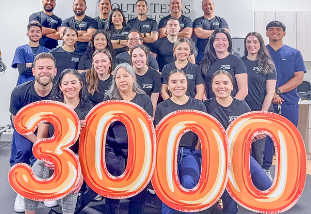 STHS McAllen Outpaitent Rehab Center Staff poses with 3000-shaped Mylar balloons