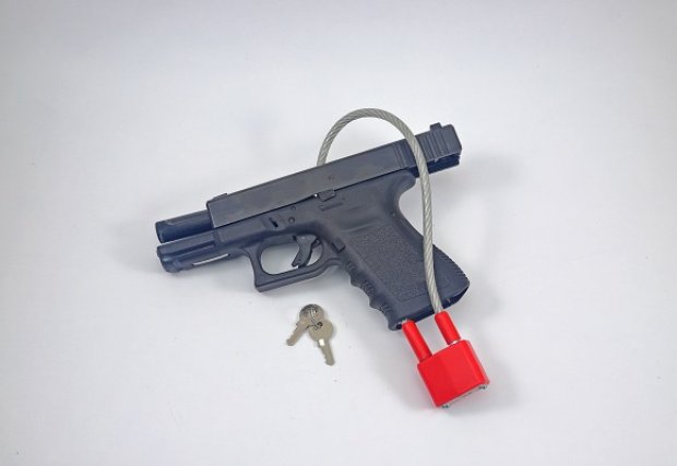 Photo of a hand gun with a safety lock attached to it