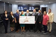 The STHS McAllen and South Texas College teams holding the large check